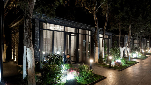 Visão externa de residência com jardim iluminado