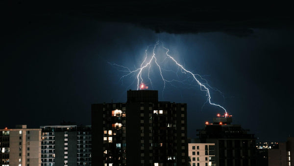 Foto do topo de prédios sob tempestade de raios